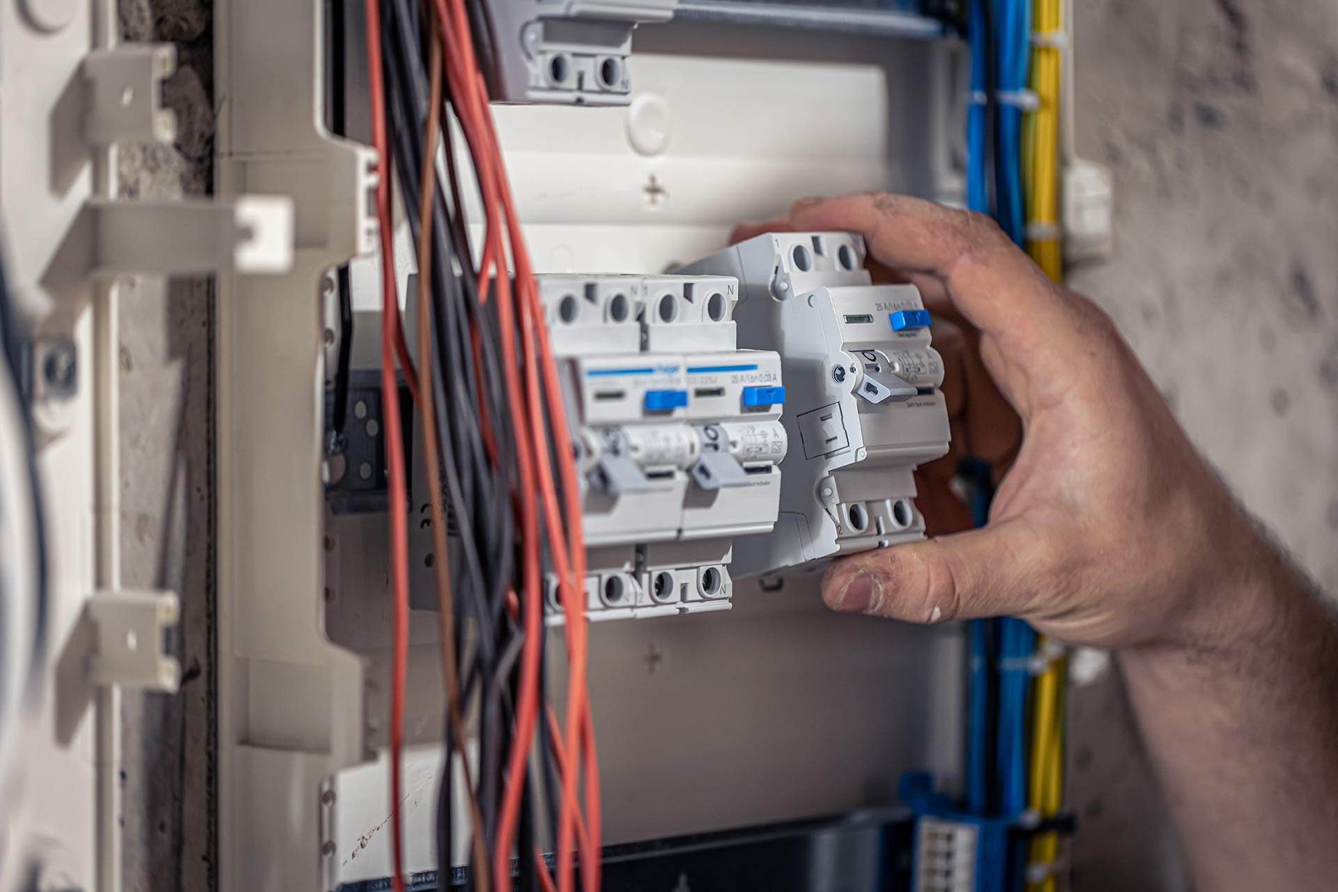 a-male-electrician-works-in-a-switchboard-with-an-2023-11-27-05-23-23-7J8VVT4.jpg